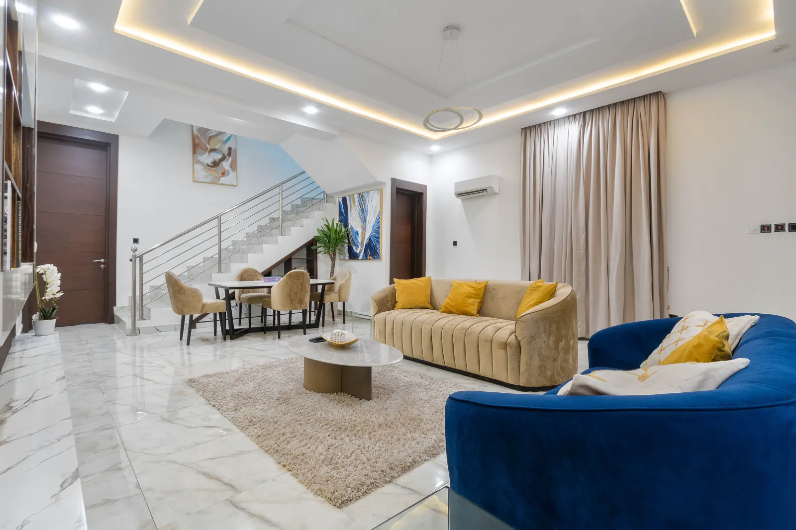 Bright lounge at Aduni's Place with blue sofas and contemporary artwork